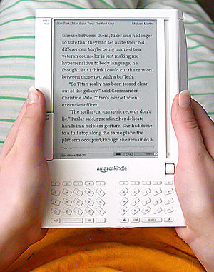 Amazon Kindle e-book reader being held by my g...